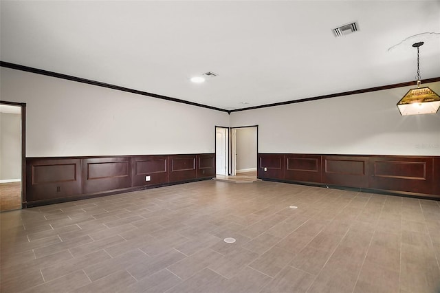 empty room featuring light wood-type flooring, visible vents, and crown molding