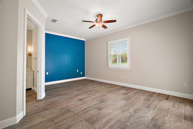 unfurnished bedroom with ornamental molding, baseboards, and wood finished floors