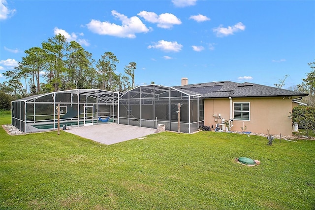 back of property with glass enclosure, a yard, a patio area, and stucco siding