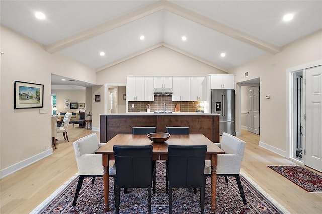 dining area featuring high vaulted ceiling, beam ceiling, and light hardwood / wood-style floors