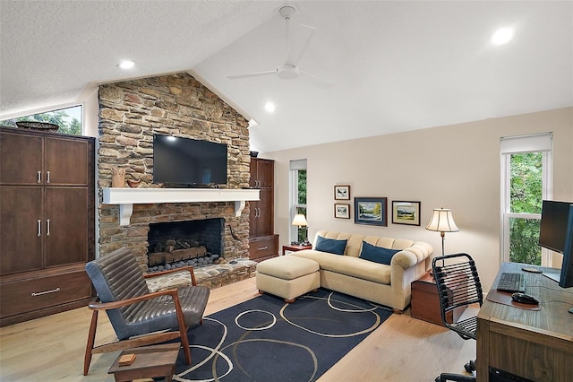 living room featuring a fireplace, vaulted ceiling, and light hardwood / wood-style floors