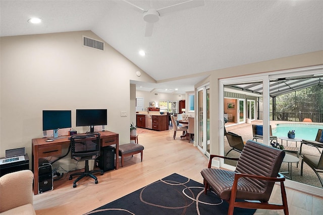 home office with ceiling fan, lofted ceiling, a textured ceiling, and light wood-type flooring