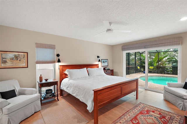 bedroom featuring ceiling fan, access to exterior, light hardwood / wood-style floors, and a textured ceiling