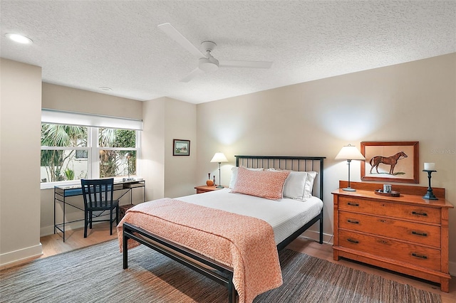 bedroom featuring hardwood / wood-style floors, a textured ceiling, and ceiling fan