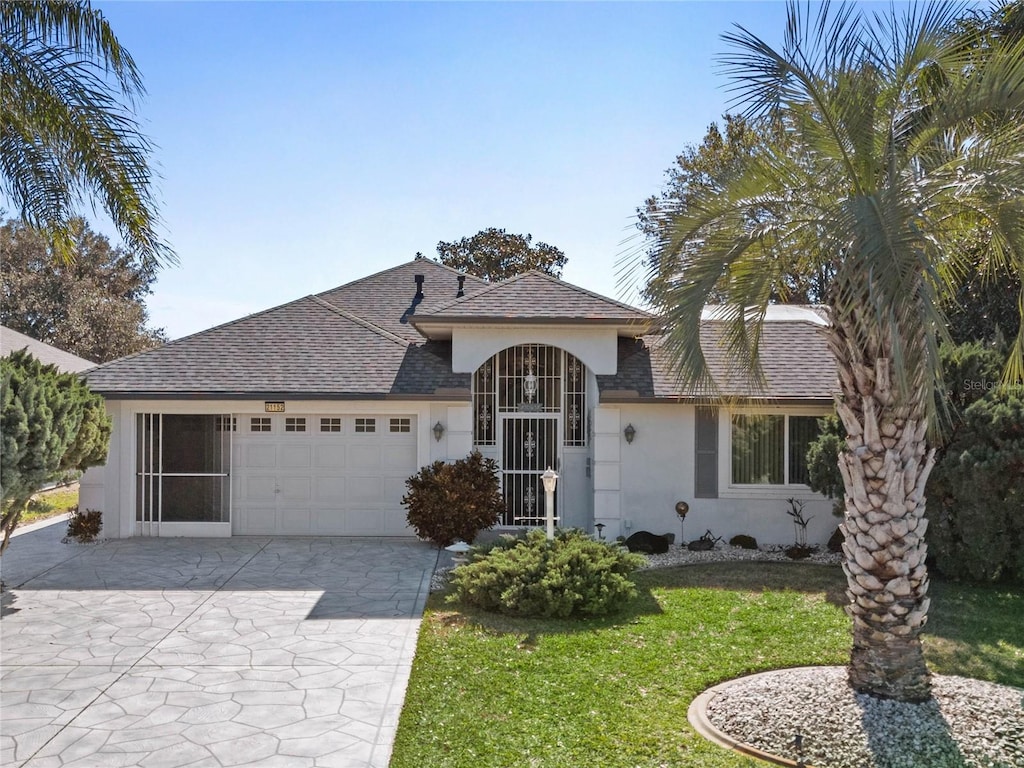 single story home featuring a garage and a front lawn