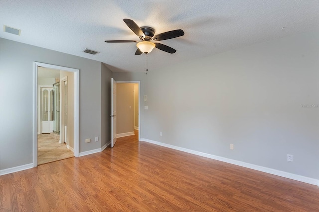 interior space featuring ceiling fan, light hardwood / wood-style floors, and a textured ceiling