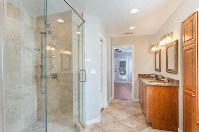 bathroom featuring vanity, an enclosed shower, tile patterned flooring, and a textured ceiling