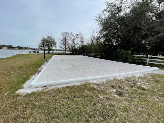 view of home's community with a water view and a yard