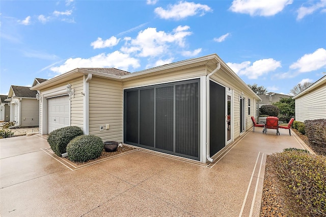 view of side of property featuring a garage and a patio area