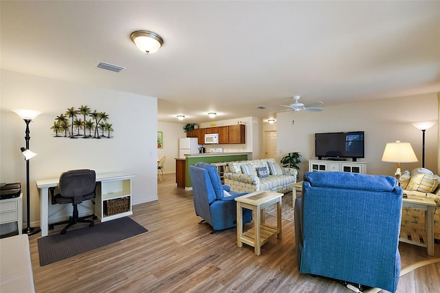 living room with light hardwood / wood-style floors and ceiling fan