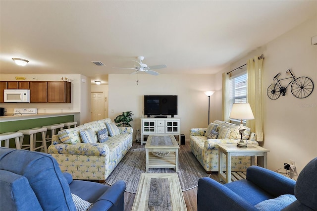 living room featuring ceiling fan and dark hardwood / wood-style floors