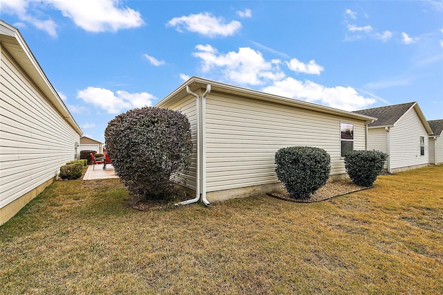 view of property exterior with a patio area and a lawn