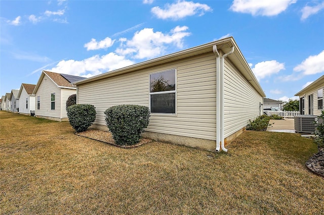 view of home's exterior with a yard and central AC