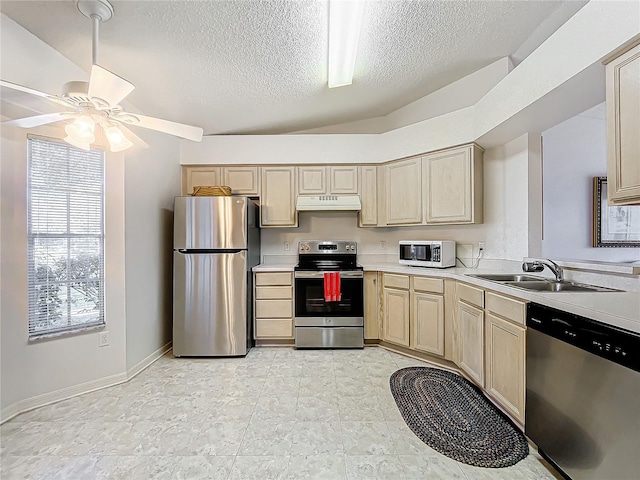 kitchen with lofted ceiling, sink, ceiling fan, stainless steel appliances, and a textured ceiling