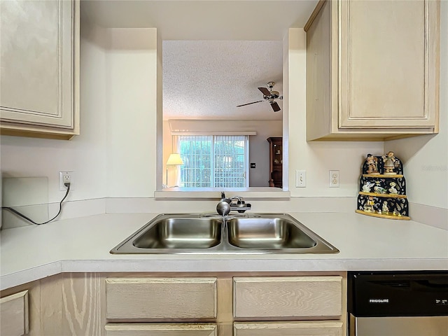 kitchen featuring sink, a textured ceiling, dishwashing machine, ceiling fan, and cream cabinets