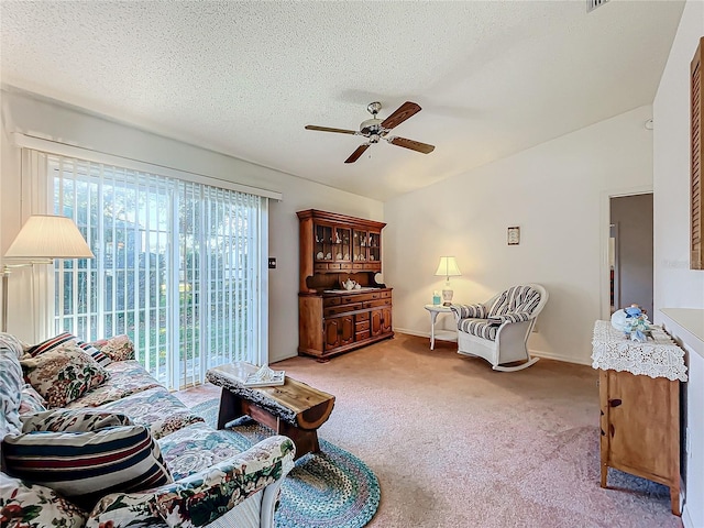 living room with ceiling fan, lofted ceiling, light carpet, and a textured ceiling