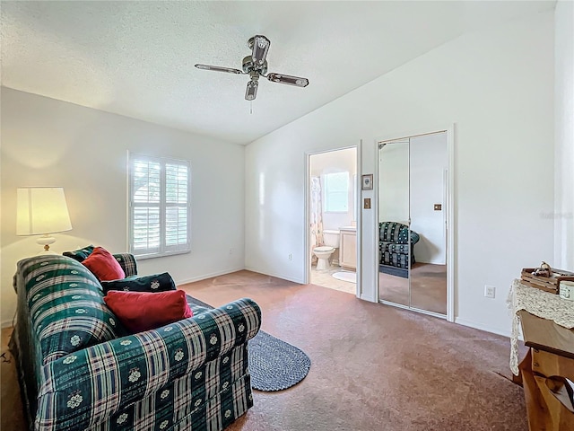 living room with carpet floors, a textured ceiling, vaulted ceiling, and ceiling fan