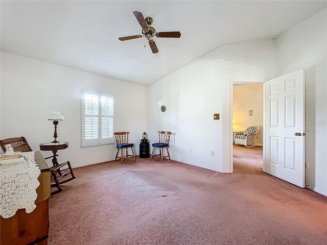 sitting room with ceiling fan, lofted ceiling, and carpet flooring