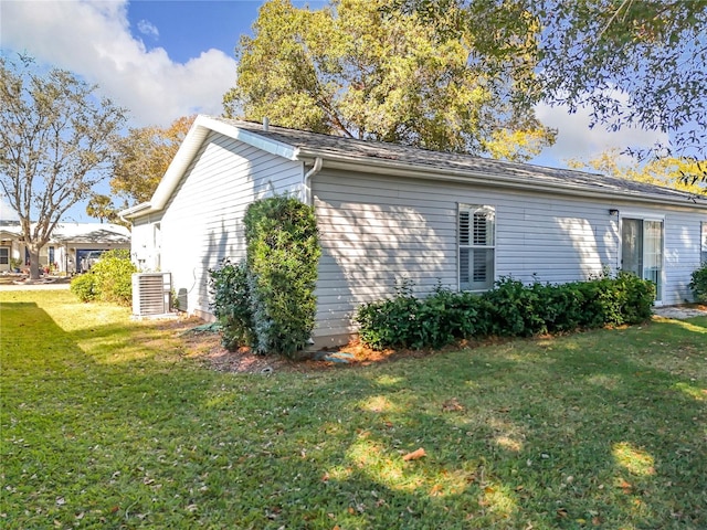 view of property exterior with a yard and central AC unit