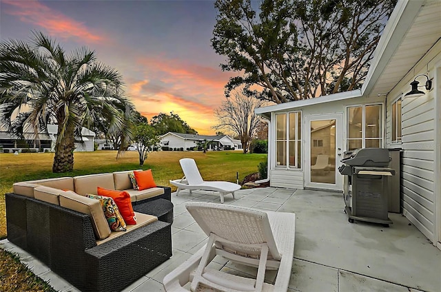 patio terrace at dusk featuring area for grilling, a yard, and an outdoor hangout area