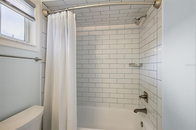 bathroom featuring shower / tub combo with curtain and toilet