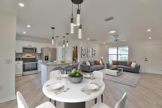 dining room with light hardwood / wood-style floors and ceiling fan