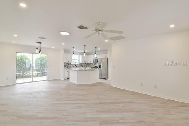 unfurnished living room featuring sink, ceiling fan, and light hardwood / wood-style flooring