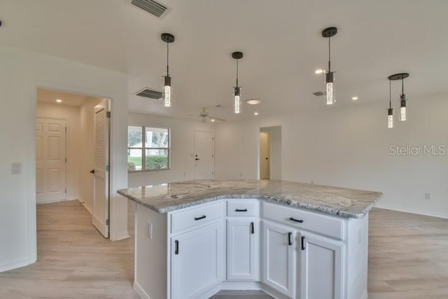 kitchen featuring white cabinetry, hanging light fixtures, and a center island