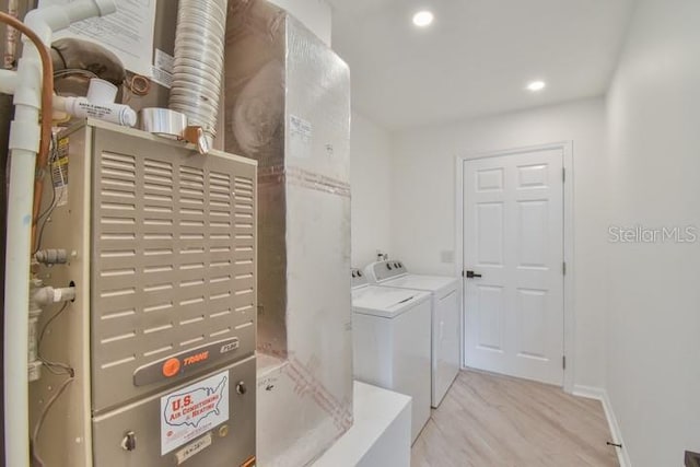 laundry area with washer and dryer and light hardwood / wood-style flooring