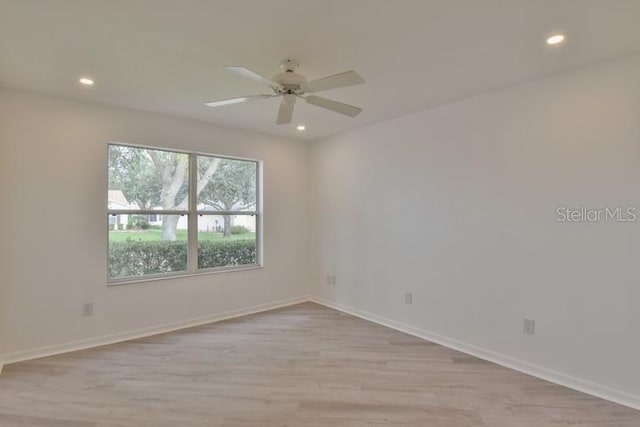 spare room featuring ceiling fan and light hardwood / wood-style flooring