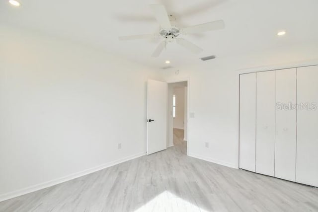 unfurnished bedroom featuring light hardwood / wood-style flooring, a closet, and ceiling fan