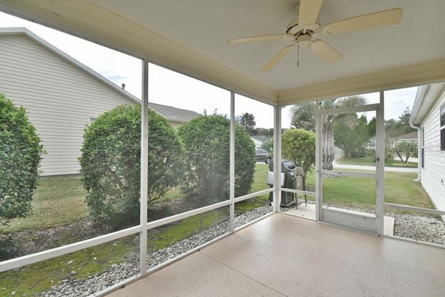 unfurnished sunroom featuring a wealth of natural light and ceiling fan