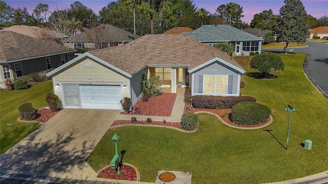 view of front of home featuring a garage and a lawn