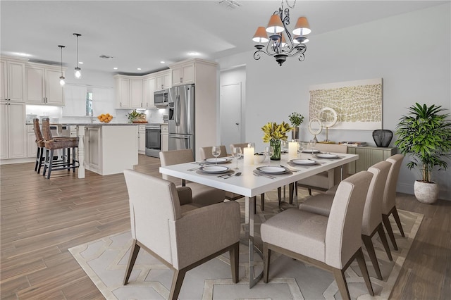 dining area featuring light hardwood / wood-style flooring and a chandelier