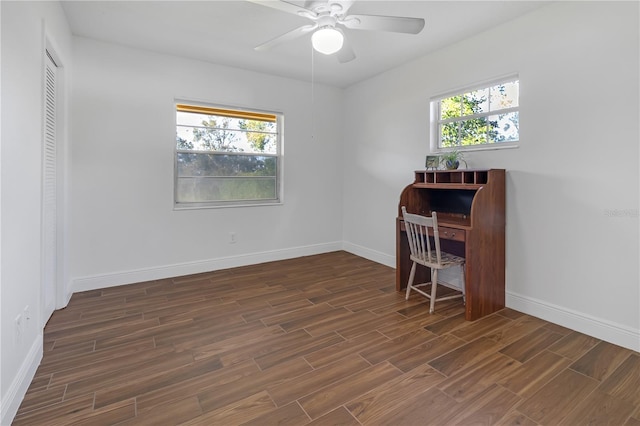 office featuring dark wood-type flooring, ceiling fan, and a healthy amount of sunlight