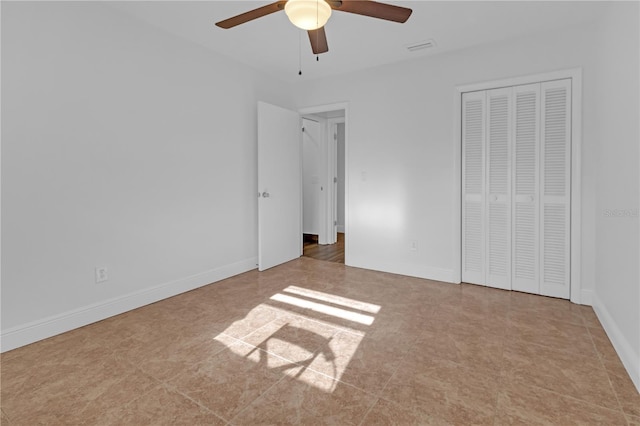 unfurnished bedroom with ceiling fan and a closet