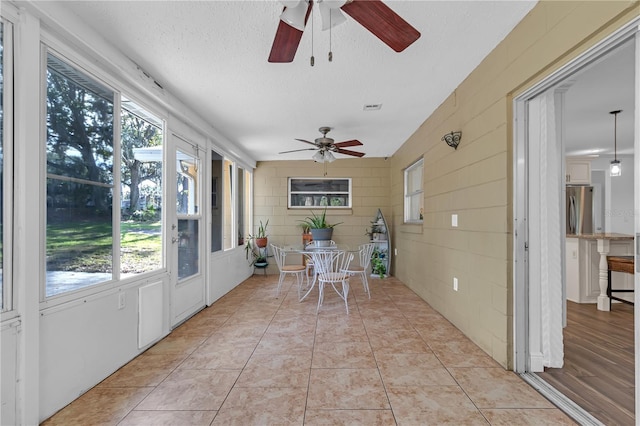 sunroom with a healthy amount of sunlight and ceiling fan