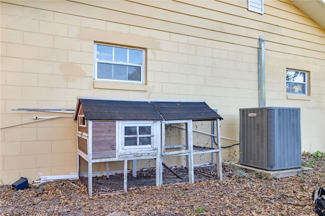 back of property featuring an outbuilding and central AC unit