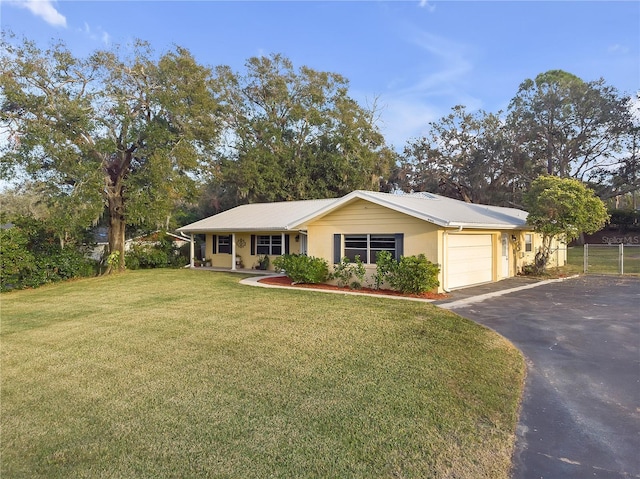 ranch-style house with a garage and a front lawn