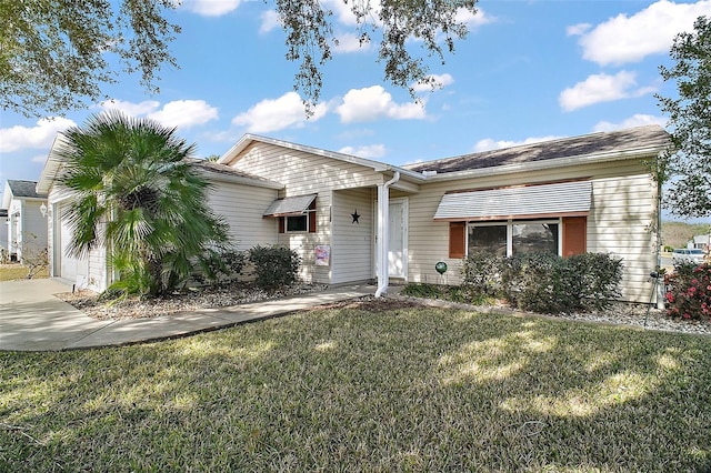 ranch-style house featuring a garage and a front lawn