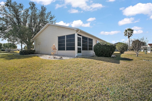 view of side of property with a sunroom and a yard