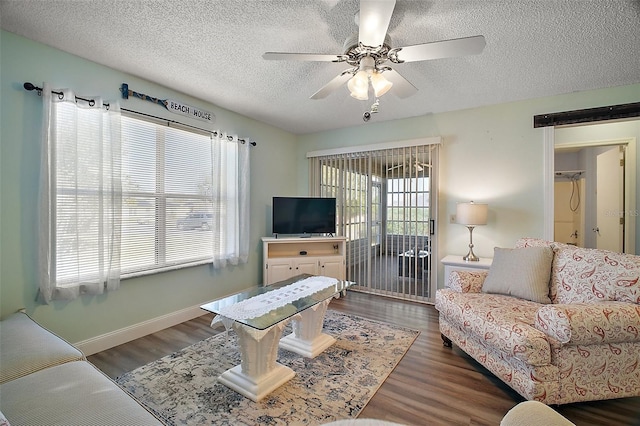 living room with ceiling fan, a textured ceiling, and dark hardwood / wood-style flooring