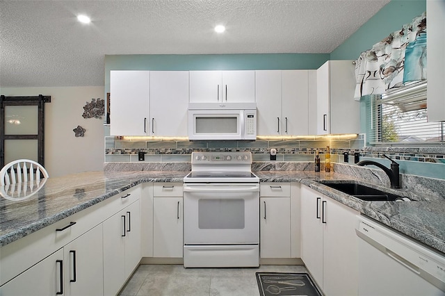 kitchen featuring sink, white appliances, and white cabinets