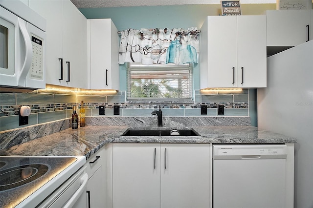 kitchen with stone countertops, tasteful backsplash, white cabinetry, sink, and white appliances