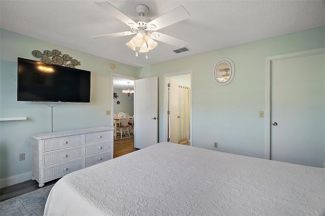 bedroom with dark hardwood / wood-style flooring, ceiling fan, and a textured ceiling