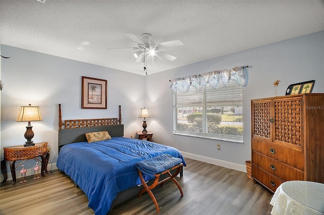 bedroom featuring hardwood / wood-style flooring, ceiling fan, and a textured ceiling