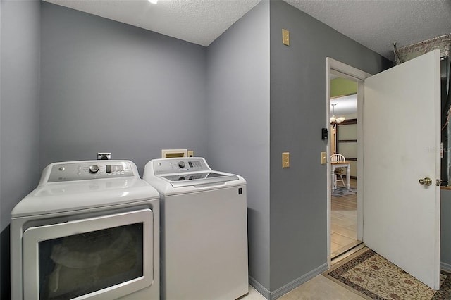 clothes washing area featuring separate washer and dryer and a textured ceiling