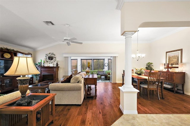 living room featuring a fireplace, crown molding, vaulted ceiling, decorative columns, and dark wood finished floors