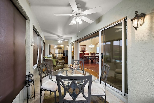 sunroom with ceiling fan with notable chandelier