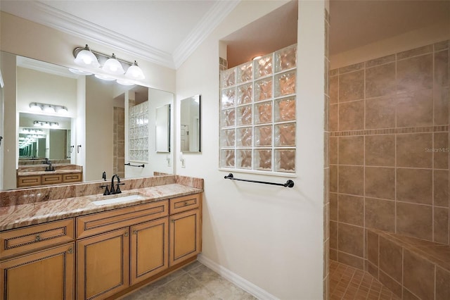 full bathroom featuring baseboards, tile patterned floors, crown molding, vanity, and a walk in shower